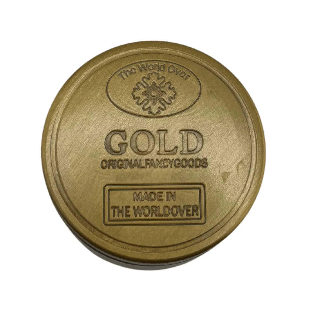 Grinder en métal doré 4 parties avec inscription GOLD et logo The World Over en relief, idéal pour accessoires CBD à Metz
