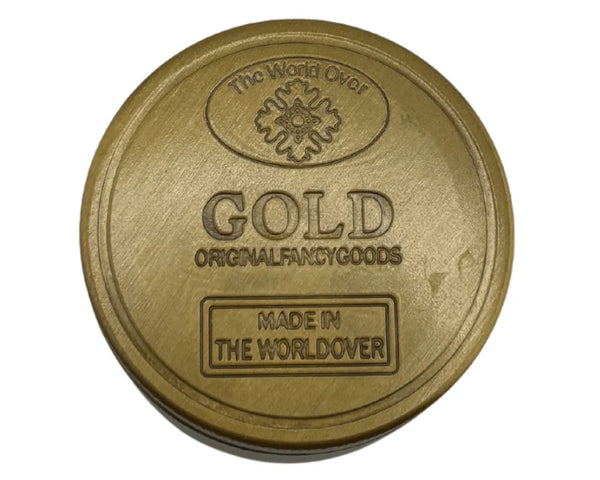 Grinder en métal doré 4 parties avec inscription GOLD et logo The World Over en relief, idéal pour accessoires CBD à Metz
