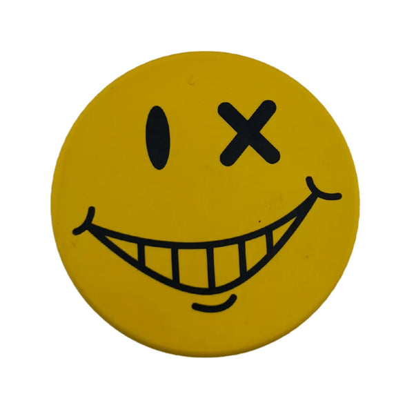 Grinder smiley jaune en métal avec visage cartoon clin d’œil et grand sourire, design rond décoratif, idéal pour accessoires CBD à Metz
